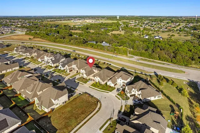 an aerial view of residential houses with outdoor space and ocean view