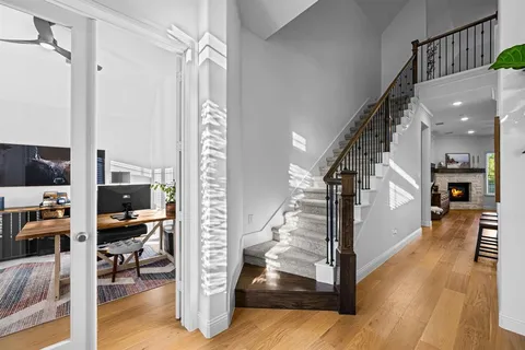 a view of a hallway view with living room and wooden floor