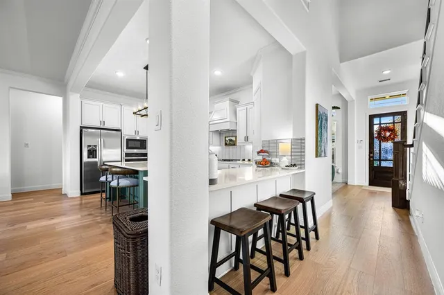 a kitchen with kitchen island white cabinets and stainless steel appliances