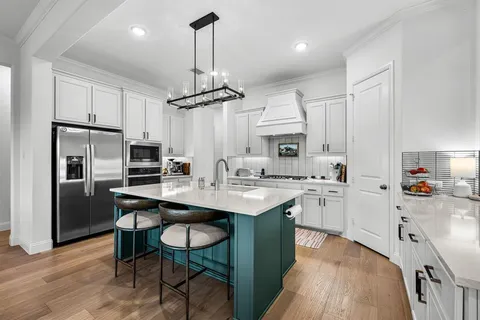 a kitchen with stainless steel appliances kitchen island a sink and cabinets