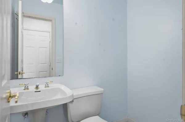 a bathroom with a toilet sink and mirror