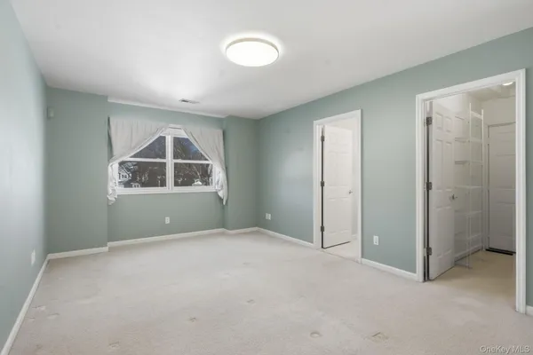a view of an empty room with glass door and a window