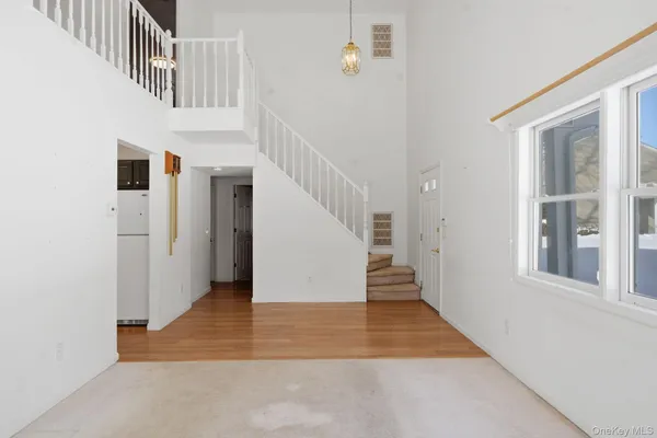 a view of a hallway with wooden floor and a kitchen