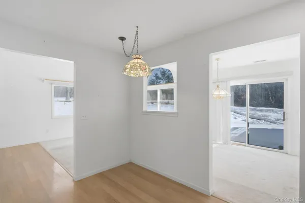 en empty room with window and wooden floor