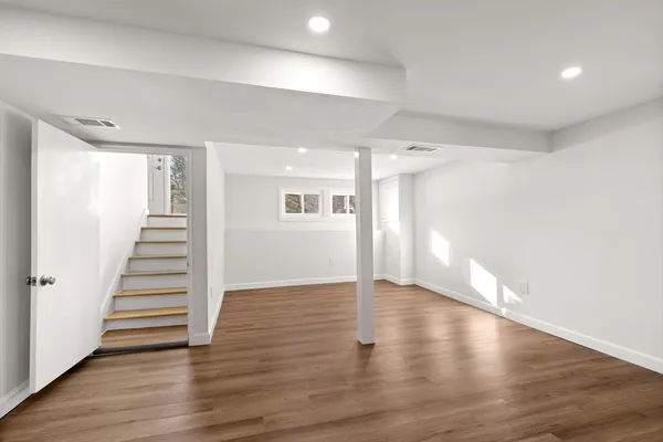 a view of an empty room with wooden floor