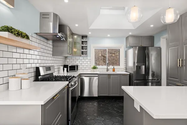 a kitchen with a sink a counter top stainless steel appliances and cabinets