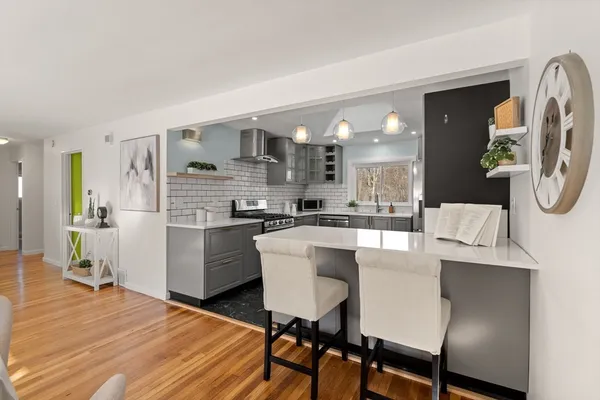 a kitchen with stainless steel appliances a dining table chairs and granite counter tops