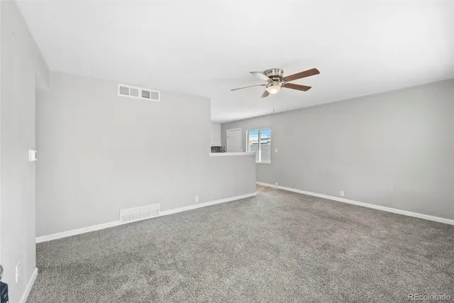 an empty room with fan and windows