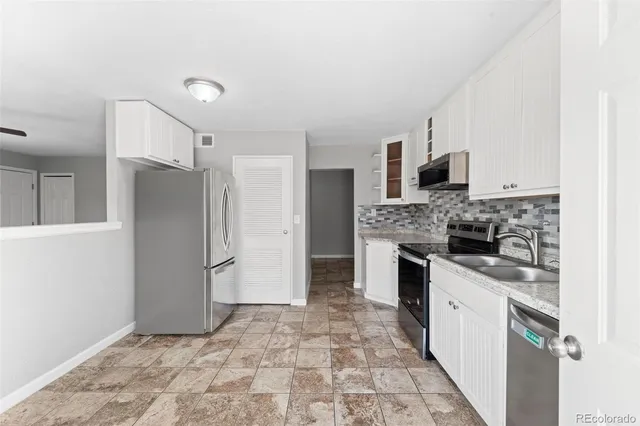a kitchen with stainless steel appliances granite countertop a refrigerator and a stove top oven