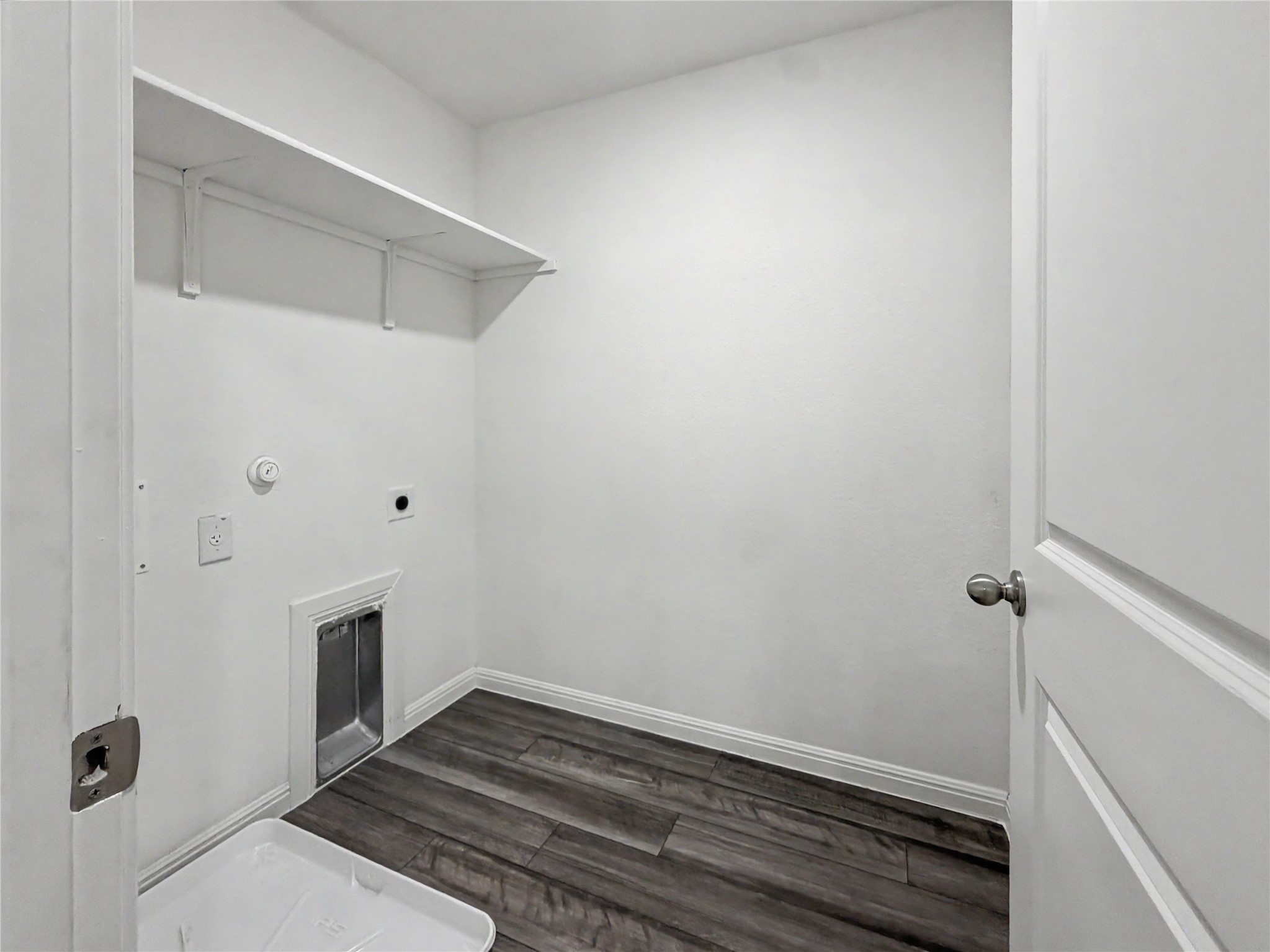 229 Night Riders Way Jarrell, TX 76537 - Photo 13 of 19 A dedicated laundry space displays functional shelving above utility hookups and wood-look flooring.