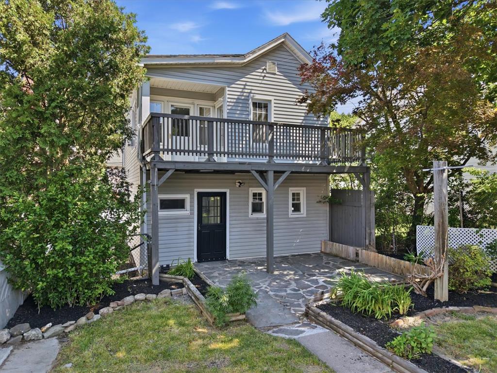 110 Messinger Street Bangor, PA 18013 - Photo 26 of 39 A charming two-story exterior boasts a deck and a flagstone patio, surrounded by mature trees and garden beds.