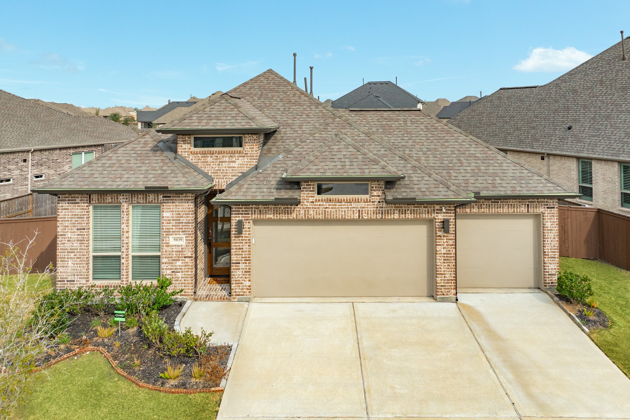 a front view of a house with a garden and garage