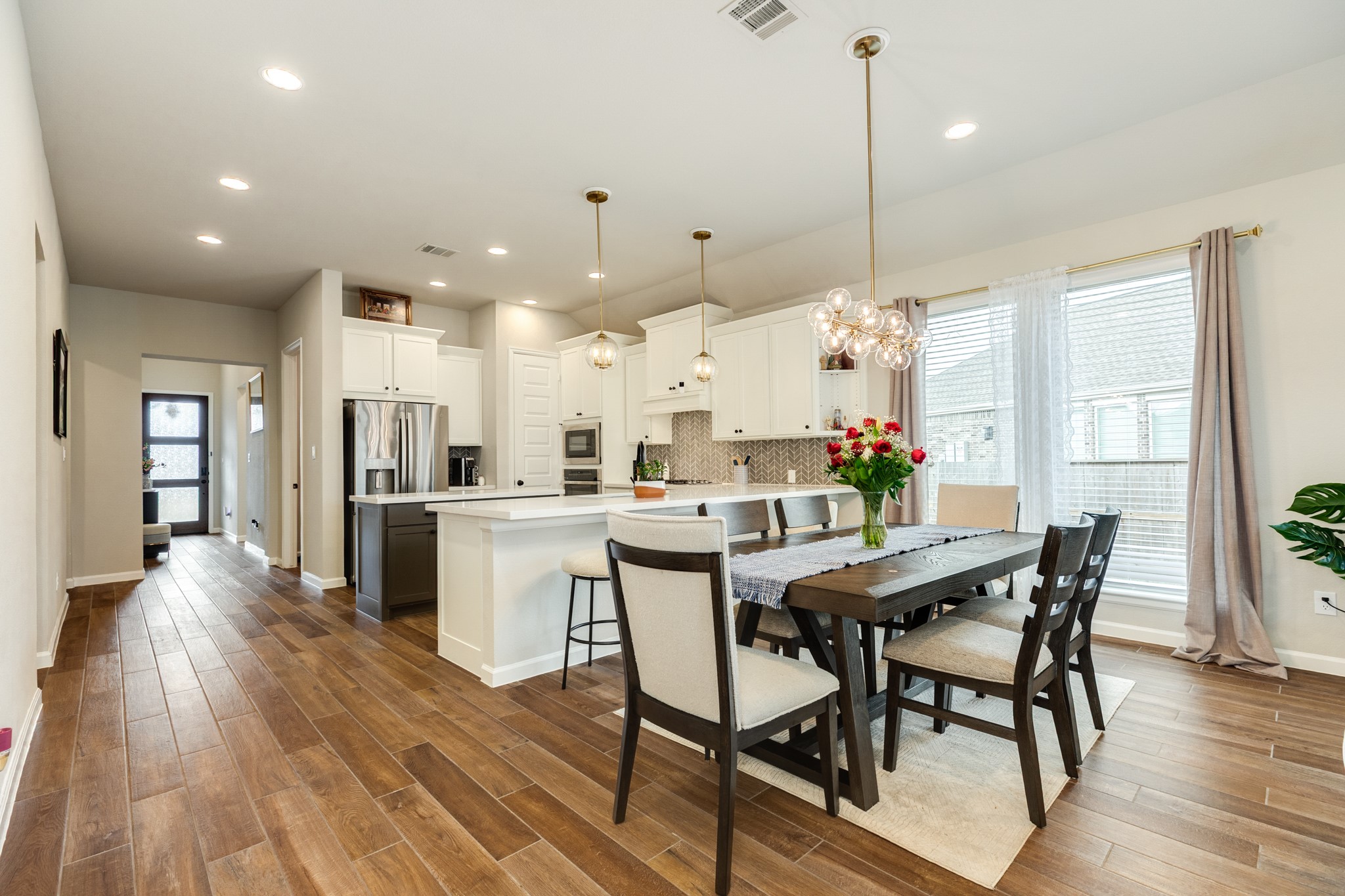 5039 Country Mdws Trail Iowa Colony, TX 77583 - Photo 11 of 50 a dining room with kitchen island stainless steel appliances furniture wooden floor and a view of kitchen
