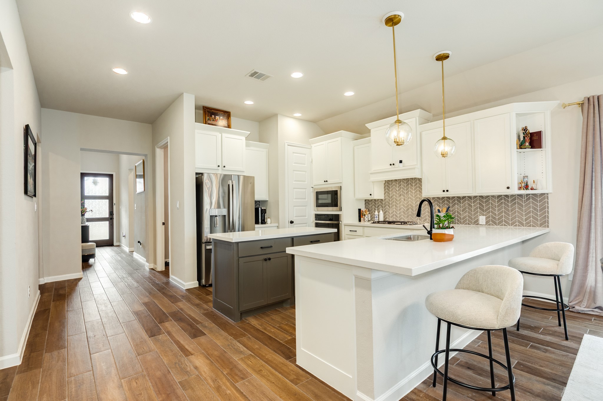 5039 Country Mdws Trail Iowa Colony, TX 77583 - Photo 7 of 50 a kitchen with stainless steel appliances kitchen island granite countertop a table chairs refrigerator and microwave