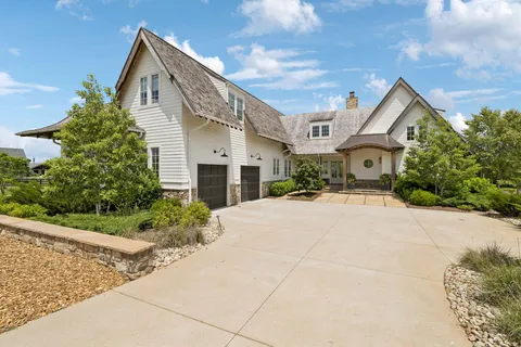 a front view of a house with a yard and potted plants