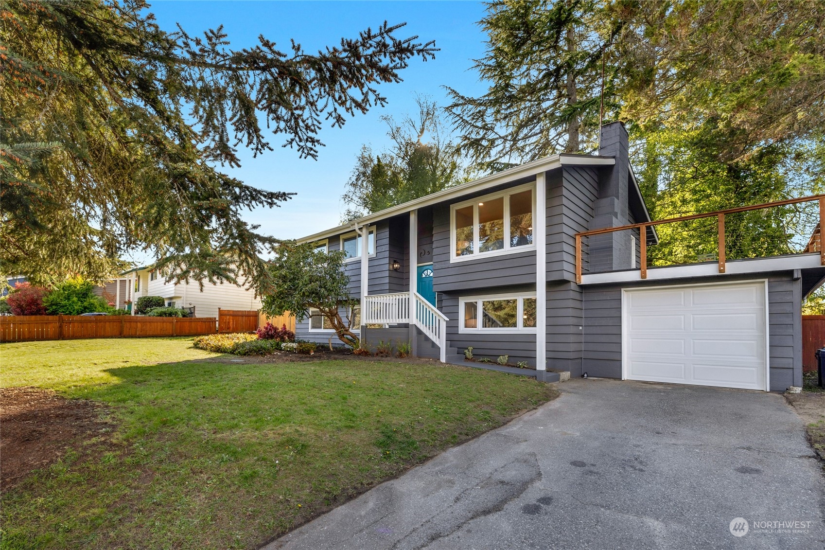 a front view of a house with a yard and trees