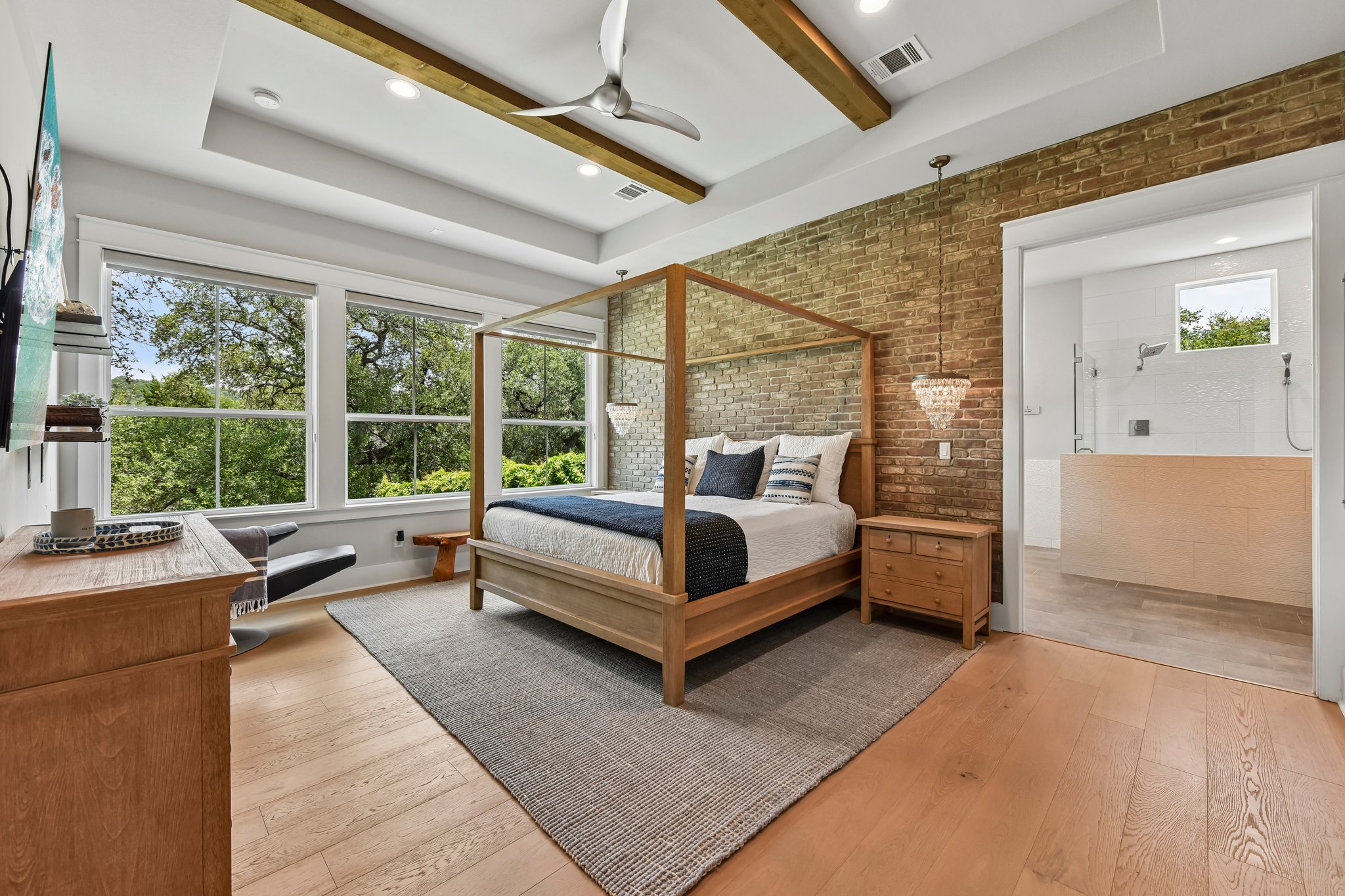 2203 Improver Road Spicewood, TX 78669 - Photo 6 of 38 Luxurious retreat offering treetop views, exposed brick accents, and a spa-like ensuite bath.