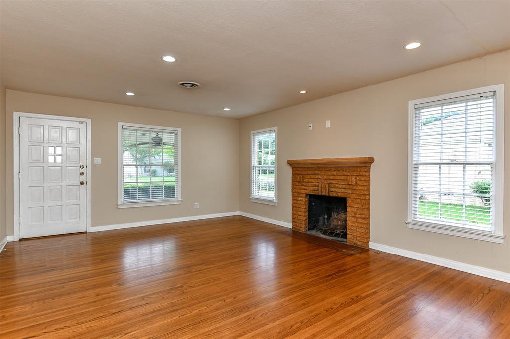 3516 Rashti Court Fort Worth, TX 76109 - Photo 4 of 24 Unfurnished living room with a fireplace and hardwood / wood-style flooring