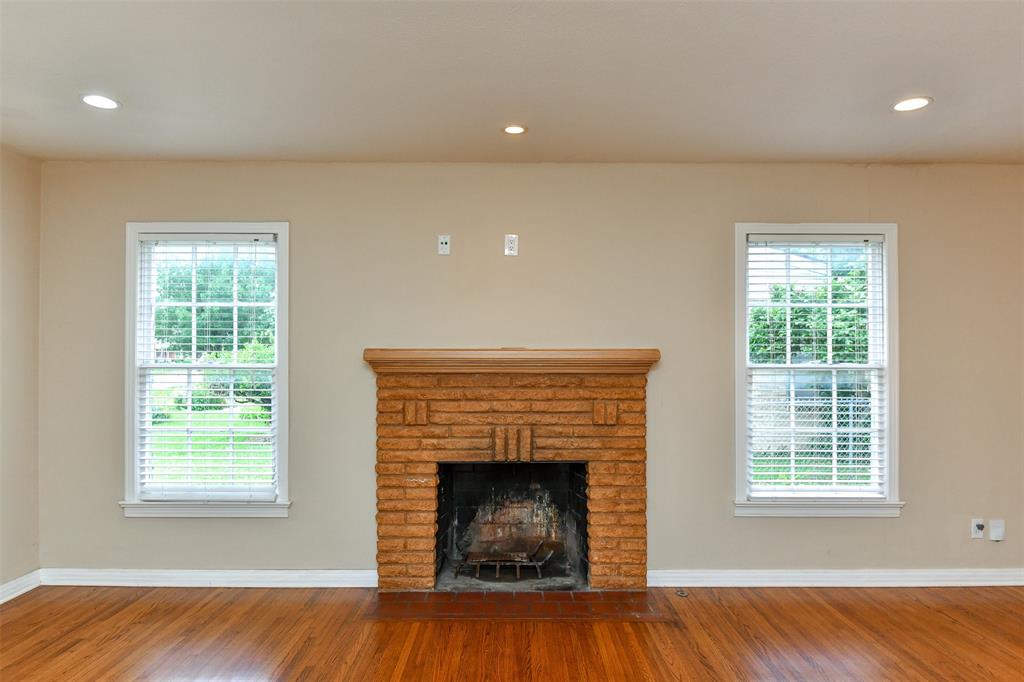 3516 Rashti Court Fort Worth, TX 76109 - Photo 5 of 24 Unfurnished living room featuring hardwood / wood-style flooring, a healthy amount of sunlight, and a fireplace
