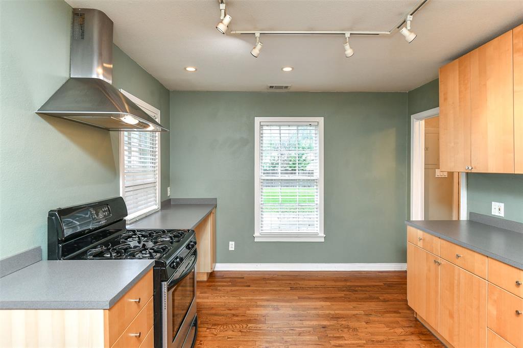 3516 Rashti Court Fort Worth, TX 76109 - Photo 9 of 24 Kitchen featuring wood-type flooring, gas stove, track lighting, and wall chimney range hood