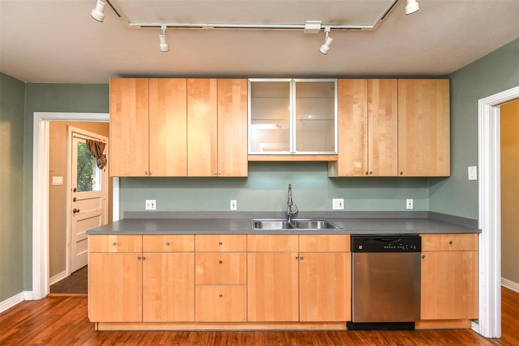 3516 Rashti Court Fort Worth, TX 76109 - Photo 10 of 24 Kitchen featuring stainless steel dishwasher, rail lighting, sink, and dark wood-type flooring
