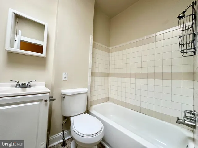 a white toilet sitting next to a bathroom sink and vanity