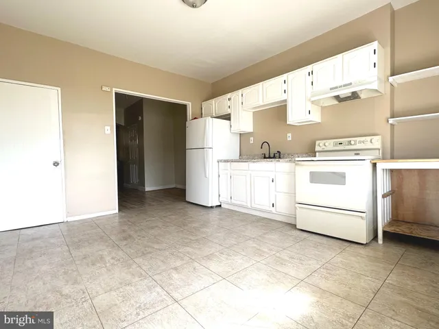 a kitchen with white cabinets and white appliances