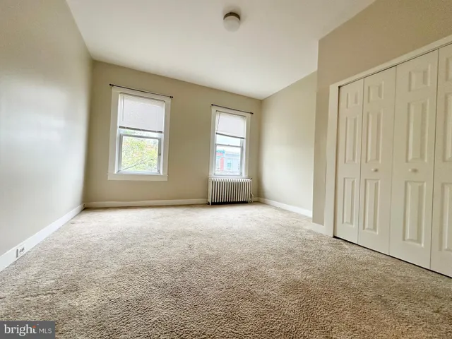 an empty room with windows and closet