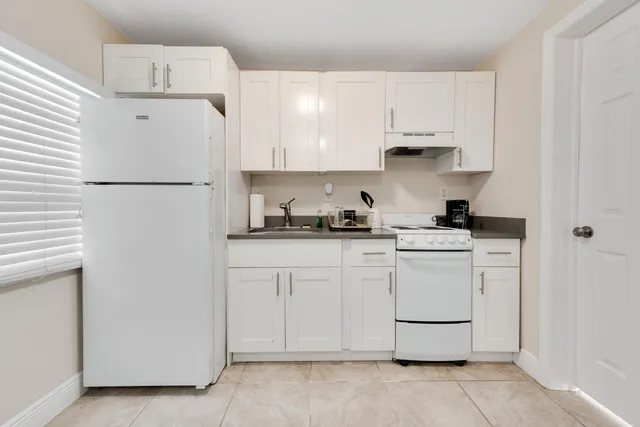 a kitchen with white cabinets and white appliances