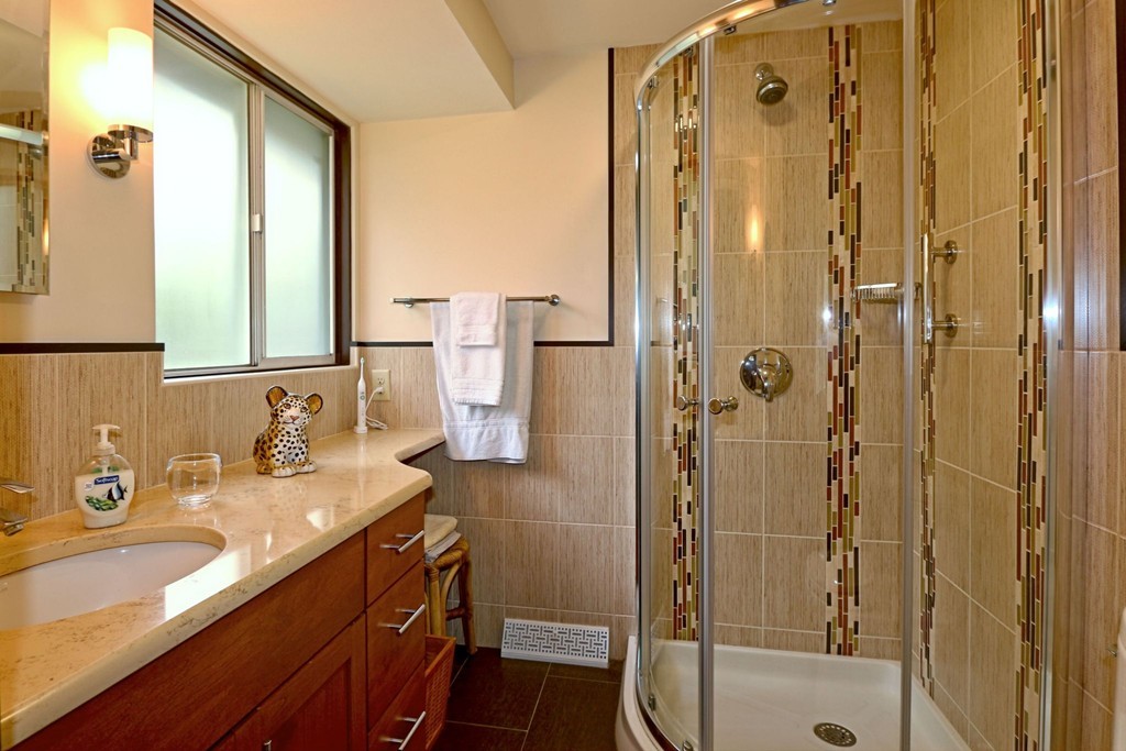 4 Holiday Road Wayland, MA 01778 - Photo 21 of 25 a bathroom with a granite countertop sink a mirror a glass door a shower and vanity