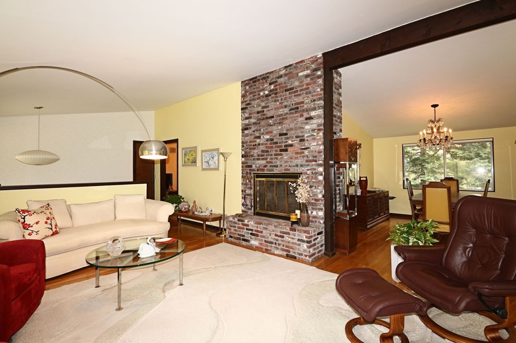 4 Holiday Road Wayland, MA 01778 - Photo 8 of 25 a living room with furniture a fireplace and a floor to ceiling window