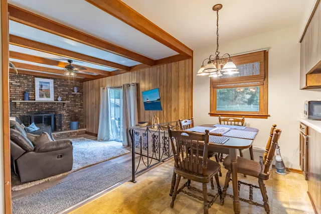 a dining room with furniture a chandelier and wooden floor
