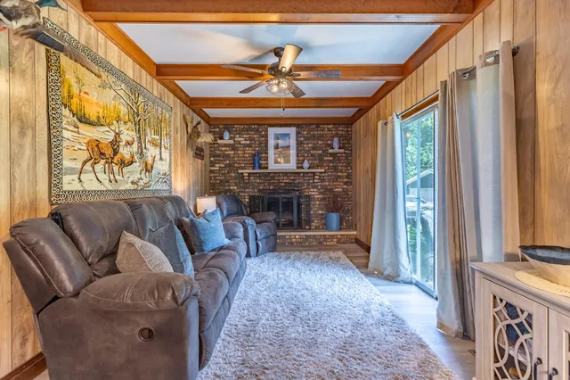 a living room with furniture a fireplace and a large window