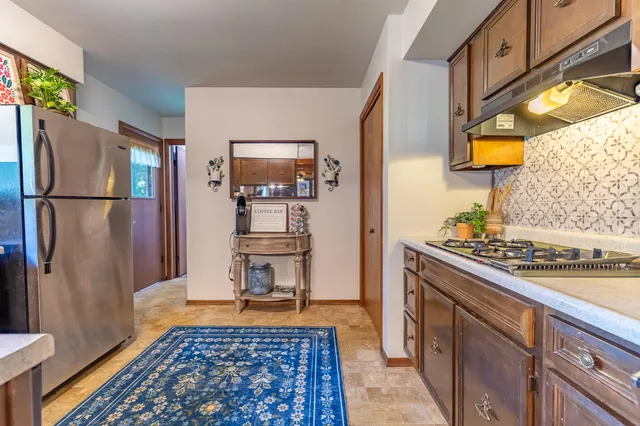a kitchen with stainless steel appliances granite countertop a refrigerator and a stove