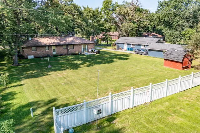 a view of a house with backyard and wooden fence