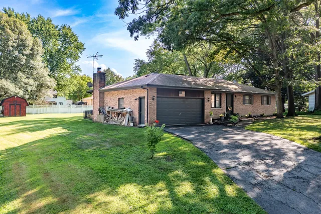 a view of a house with backyard and a tree