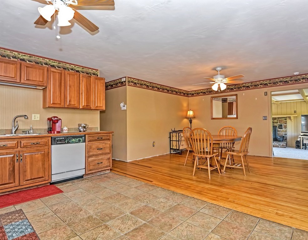 88 Rice Corner Road Brookfield, MA 01506 - Photo 12 of 39 a kitchen with granite countertop a table chairs stove and cabinets