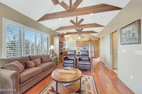 a living room with furniture large window and wooden floor