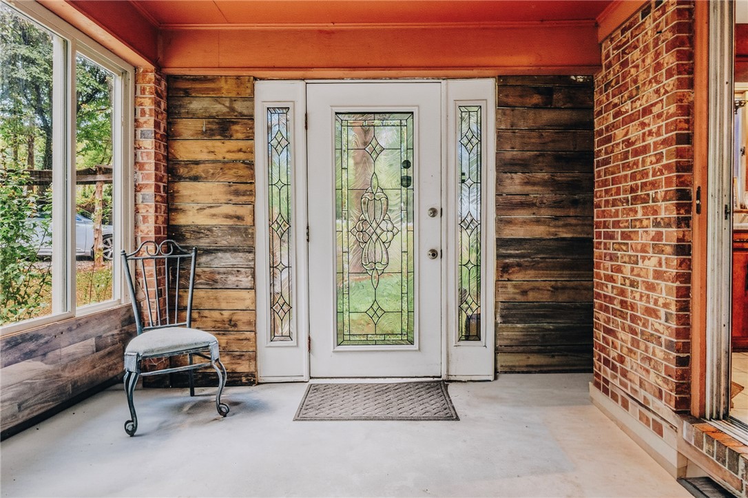 707 Campbell Town Road Walhalla, SC 29691 - Photo 20 of 44 An inviting sunroom door presents leaded glass details alongside rustic brick and timber accents from the inside.