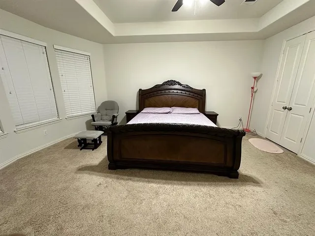 a spacious bedroom with a bed and a ceiling fan