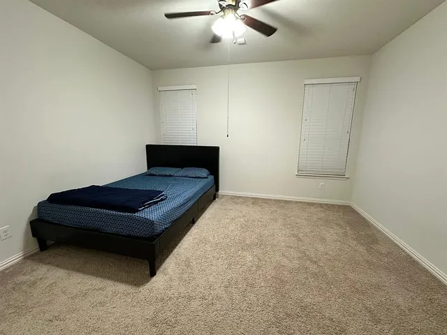 a living room with furniture and a ceiling fan