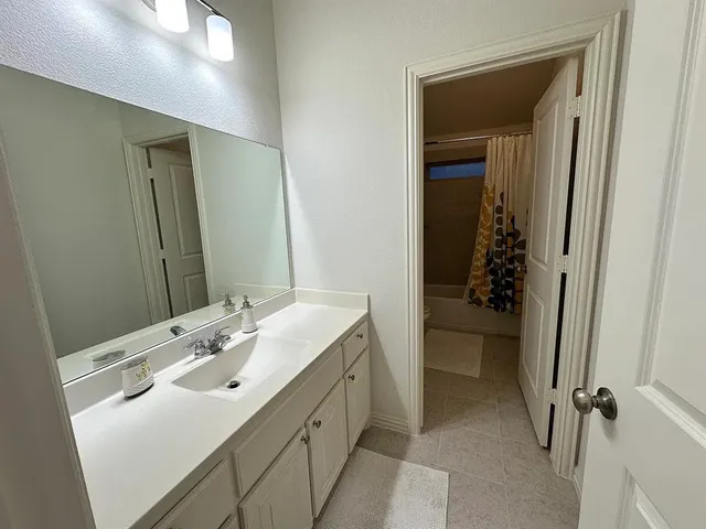 a bathroom with a sink and mirror with toilet