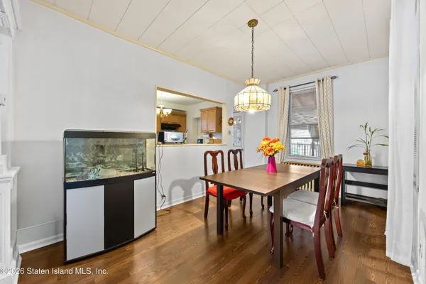 a dining room with furniture a chandelier and wooden floor