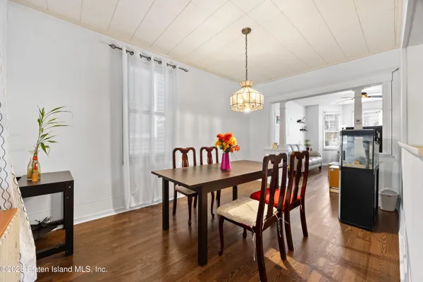 a dining room with furniture a chandelier and wooden floor