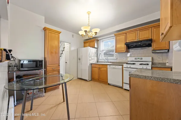 a kitchen with stainless steel appliances a stove top oven a sink a counter top space and cabinets