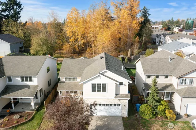 an aerial view of house with yard and trees in the background