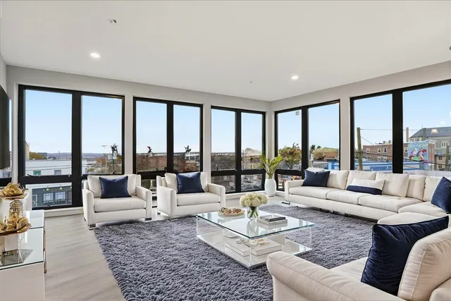 a living room with furniture and floor to ceiling windows