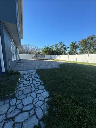 a view of a backyard with potted plants and wooden fence