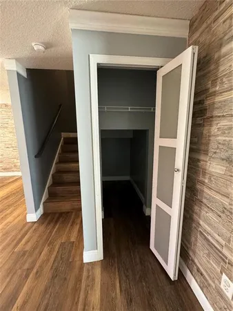 a view of a hallway with wooden floor and staircase