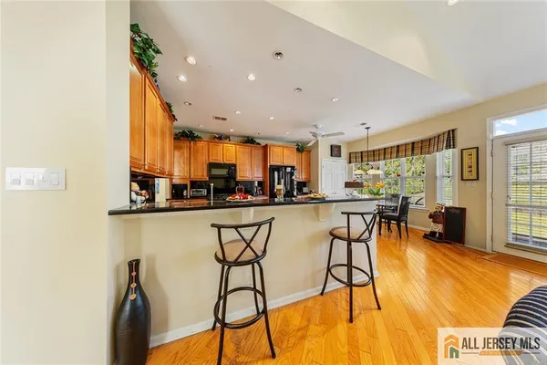a kitchen with stainless steel appliances kitchen island granite countertop a table and chairs in it